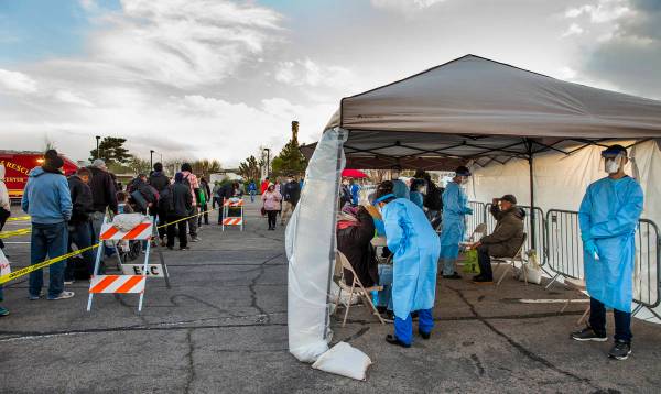 Touro University Nevada medical students, right, screen the homeless as they enter the temporar ...