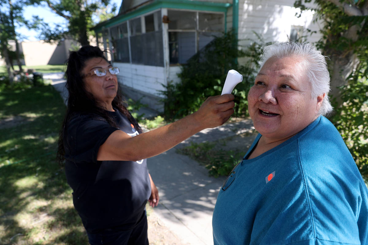 Deanna Garcia, left, checks the temperature of an unidentified member at Walker River Paiute Tr ...
