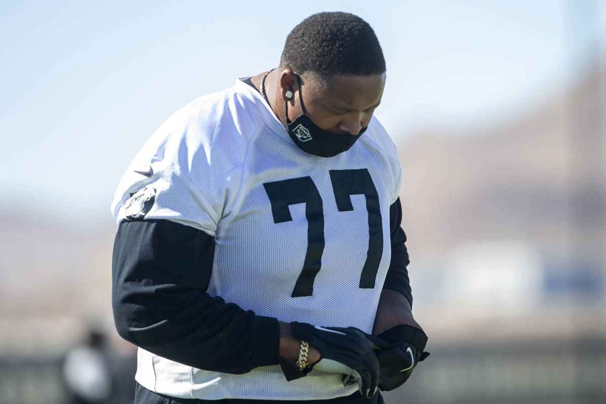 Las Vegas Raiders offensive tackle Trent Brown (77) warms up with a mask on during a practice ...