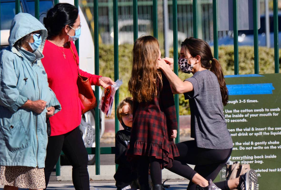 A woman swabs a child at an outside COVID-19 testing site in the North Hollywood section of Los ...