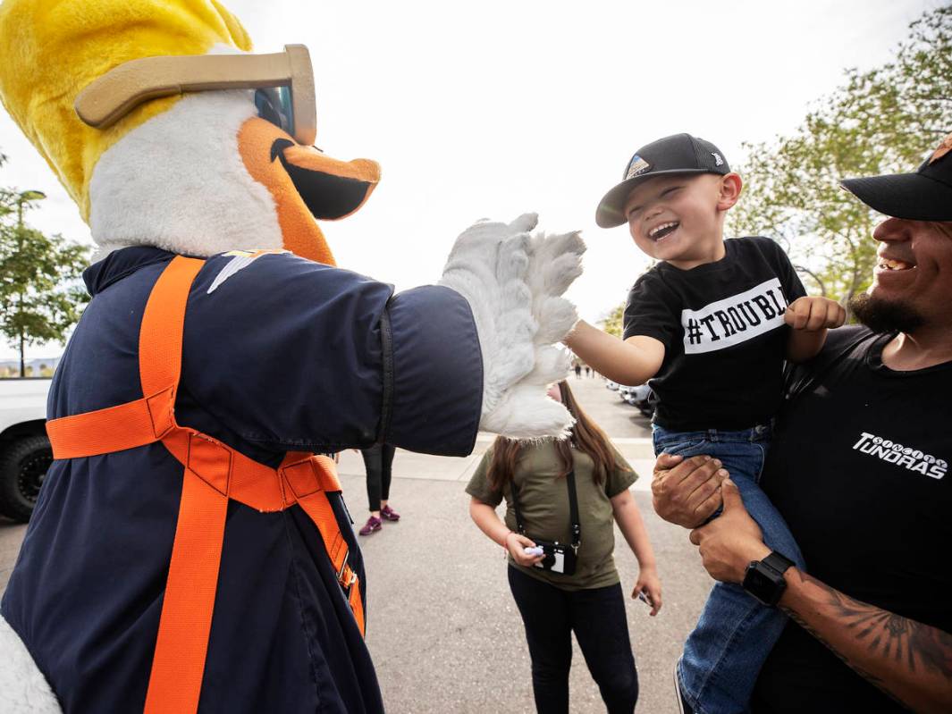 Las Vegas Aviators mascot Spruce the Goose, left, high-fives Jessie Yanez, 4, during a vehicle ...