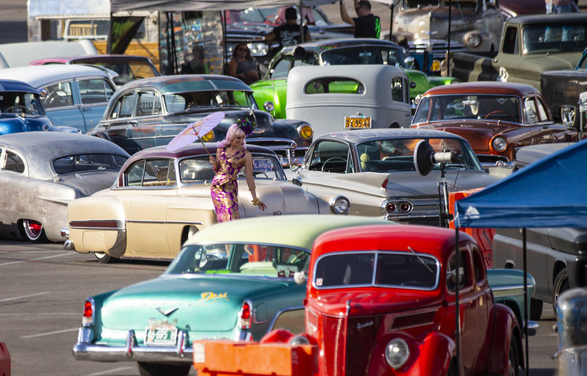 A model poses as vintage vehicles are set up ahead of the car show during the first day of Viva ...