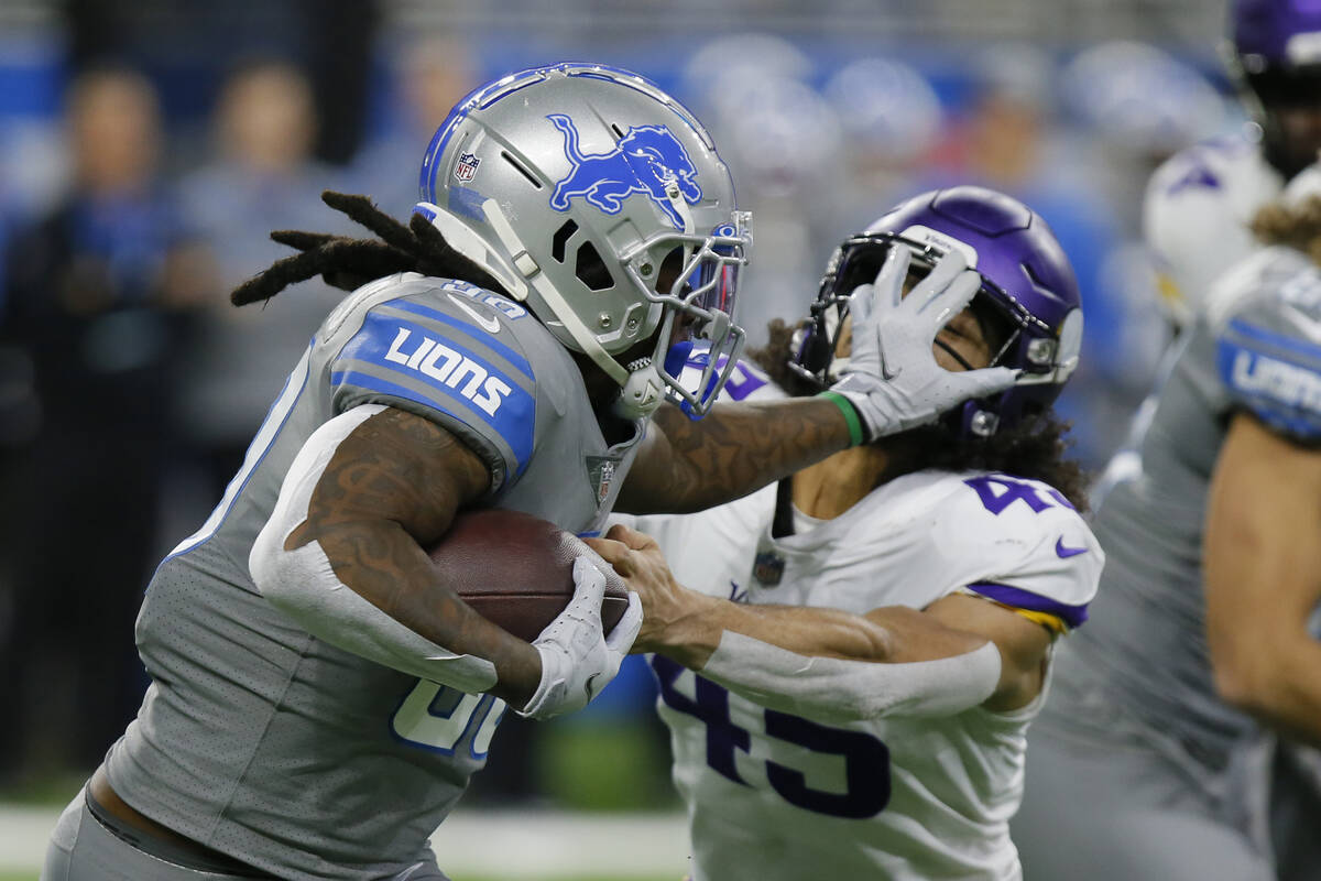 Detroit Lions running back Jamaal Williams (30) stiff arms Minnesota Vikings linebacker Troy Dy ...