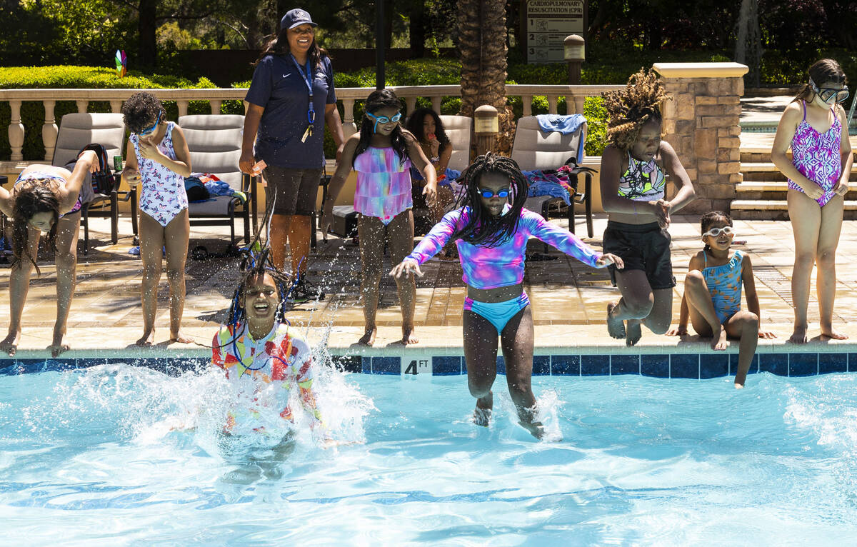 Children jump into the pool during a celebratory pancake breakfast and pool party held by the O ...