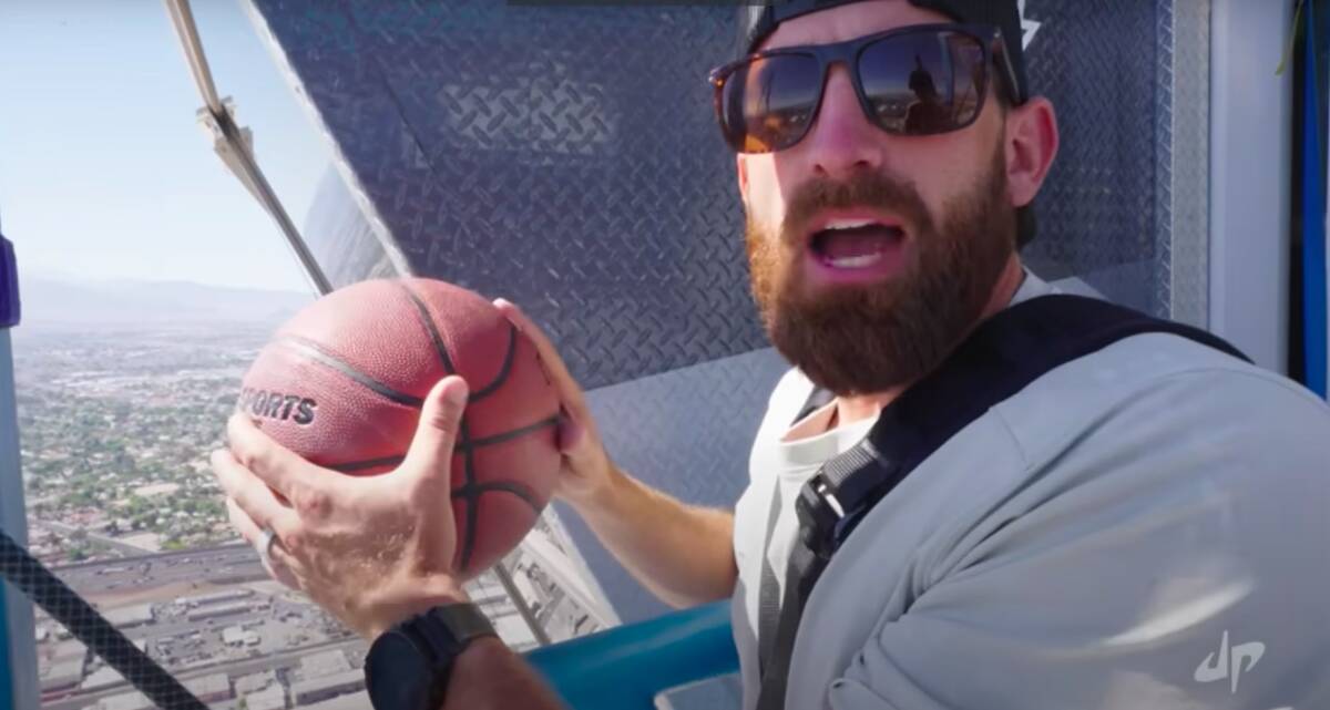 A screenshot of Dude Perfect co-founder Tyler Toney attempts the world's highest basketball sho ...