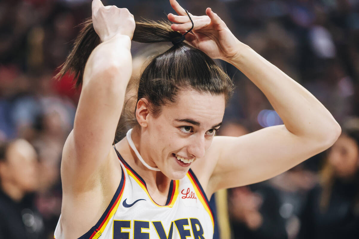 Indiana Fever guard Caitlin Clark (22) ties her hair up before a game between the Aces and Indi ...