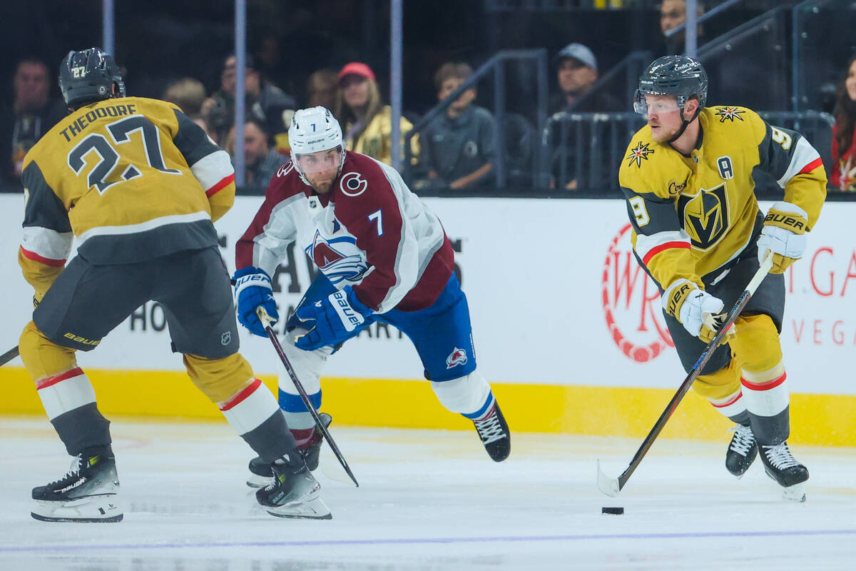 Golden Knights center Jack Eichel (9) pushes the puck away from Colorado Avalanche defenseman D ...