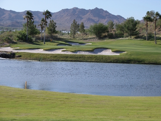Hole No. 8 at Coyote Run at Boulder Creek Golf Club is a challenging 142-yard par-3 guarded by water and sand traps.