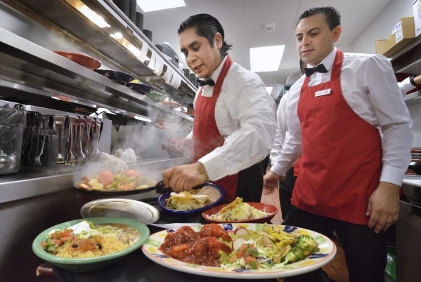 Expediter Miguel Chavez, left, places a dish on a tray as Alfonso Barragan waits to take the orders to a table at PanchoÃ¾ÃÃ´s at 11020 Lavender Hill Drive in Downtown Summerlin in Las Vega ...