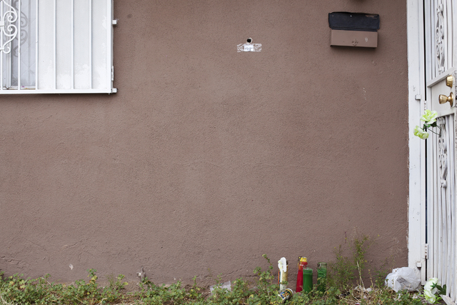 A bullet hole in the wall of the house near candles and flowers is seen Monday, April 25, on the 2400 block of Page Street where a 24-year-old man was found shot to death early Sunday morning in L ...
