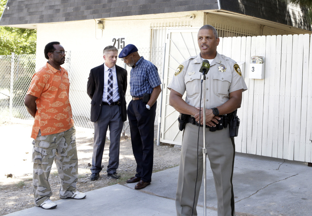 Las Vegas police Capt. Robert Plummer speaks about an arrest made in a triple homicide, as he briefs the media as Metro Lt. Dan McGrath, second left, talks to community organizers on Tuesday, May  ...