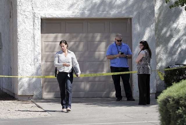 Phoenix police detectives stand outside a home, Thursday, June 2, 2016, where three boys were killed Wednesday night.  The boy's mother was hospitalized in critical condition with self-inflicted s ...