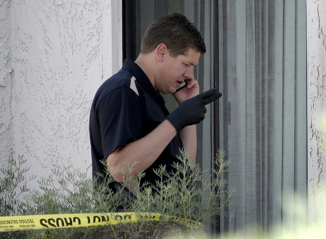 A Phoenix police detective stands outside a home, Thursday, June 2, 2016, where three boys were killed Wednesday night.  The boy's mother was hospitalized in critical condition with self-inflicted ...