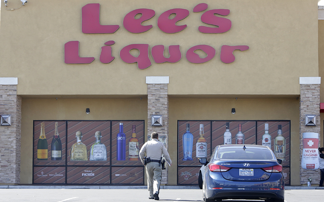 A Metro police officer investigates Tuesday, April 19, 2016 after a Lee's Discount Liquor employee Matthew Christensen, 24, was shot and killed during a robbery Monday night at the liquor store at ...