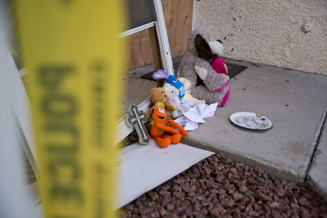 Toys, and other items placed by local residents, sit outside the boarded apartment, where Jason Dej-Oudom killed himself and his three children on Wednesday night, in Las Vegas on Friday, July 1,  ...