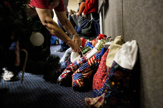 A volunteer during the 8th annual &quot;Stockings for our Troops,&quot; straightens the filled stockings for active troops overseas, Henderson City Hall, Tuesday, Nov. 29, 2016, in Henders ...