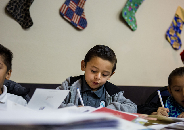 David Espino, 6, a student from Gordon McCaw Elementary School, writes a letter for an active troop overseas during the 8th annual &quot;Stockings for our Troops,&quot; at Henderson City H ...