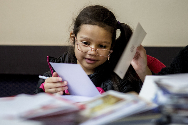 Aurora Guerir-Bolt, 6, a student from Gordon McCaw Elementary School, writes a letter for an active troop overseas during the 8th annual &quot;Stockings for our Troops,&quot; at Henderson  ...