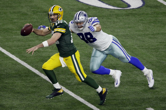 Green Bay Packers quarterback Aaron Rodgers (12) is pressured by Dallas Cowboys defensive end Tyrone Crawford (98) during the second half of an NFL divisional playoff football game Sunday, Jan. 15 ...