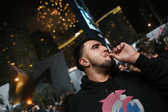 Kevin Melendres, 21, smokes Cannabis at midnight on New Year's day at the the Strip on Sunday, Jan. 01, 2017, in Las Vegas. Recreational marijuana is legal in Nevada starting Sunday, Jan. 01, 2017 ...