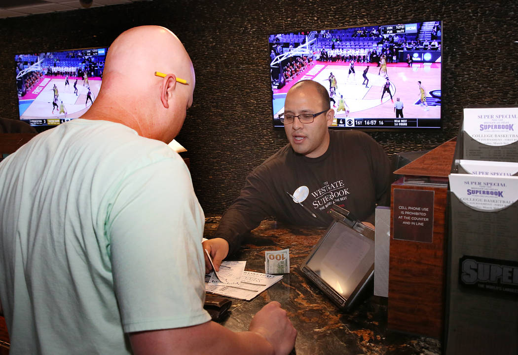 Ryan Ward, left, of Phoenix, Ariz., places his bet on the NCAA basketball tournament at Westgate sports book on Thursday, March 16, 2017, in Las Vegas. (Bizuayehu Tesfaye/Las Vegas Review-Journal) ...