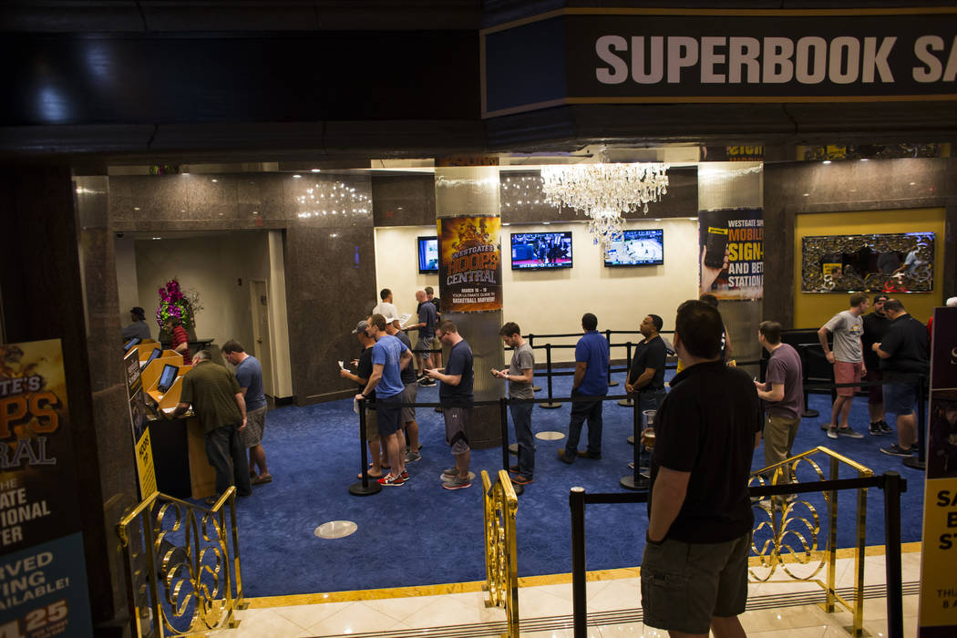 People line up to place bets at a satellite betting location in the Westgate hotel-casino during the first day of the NCAA basketball tournament in Las Vegas on Thursday, March 16, 2017. (Chase St ...