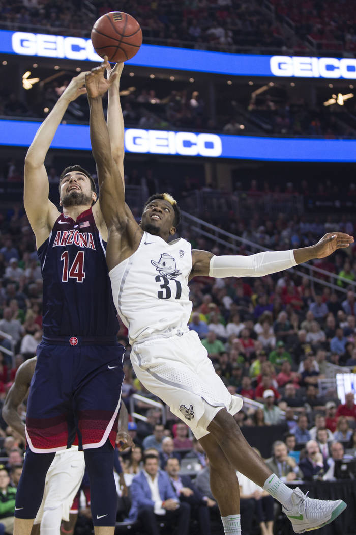 Arizona Wildcats center Dusan Ristic (14) and Oregon Ducks guard Dylan Ennis (31) fight for the ball in an NCAA college basketball game for the Pac-12 tournament championship at T-Mobile Arena Sat ...