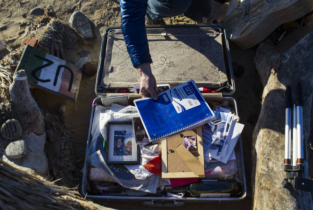 A briefcase with tributes and memorabilia from fans of rock band U2 sits with the fallen tree t ...