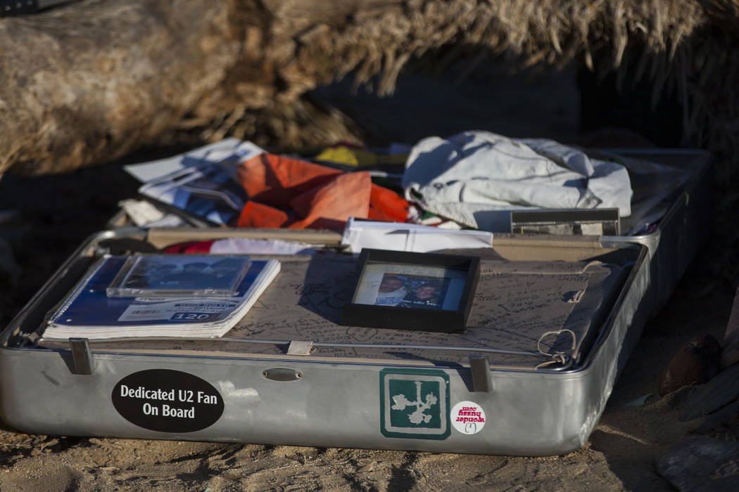 A briefcase with tributes and memorabilia from fans of rock band U2 sits with the fallen tree t ...