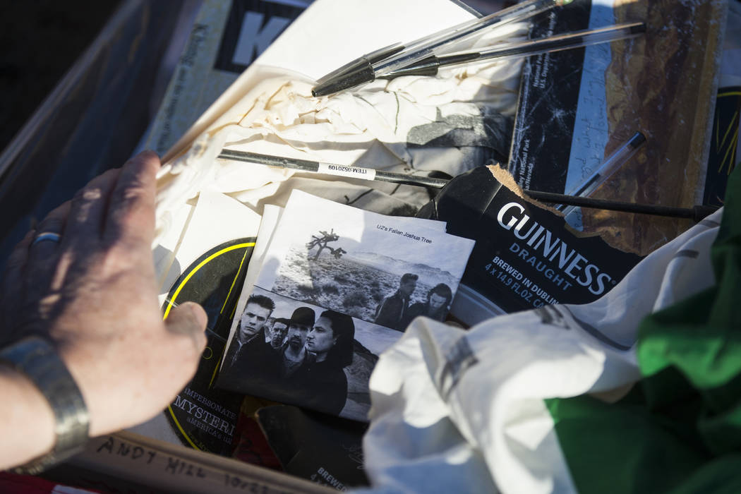 A briefcase with tributes and memorabilia from fans of rock band U2 sits with the fallen tree t ...