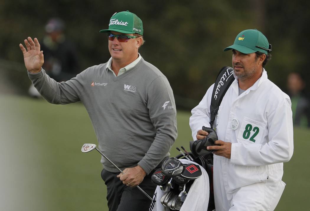 Charley Hoffman waves as he walks up the 18th fairway with his caddie Brett Waldman in first round play during the 2017 Masters golf tournament at Augusta National Golf Club in Augusta, Georgia, U ...