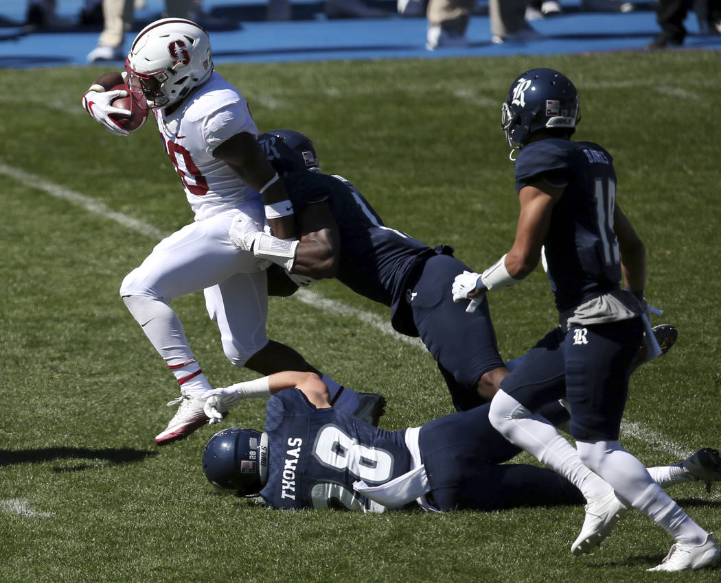 Stanford's running back Bryce Love, left, breaks tackles as he runs against the Rice defence during the opening game of the U.S. college football season in Sydney, Sunday Aug. 27, 2017. (AP Photo/ ...