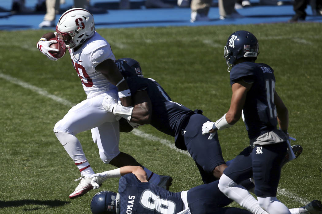 Stanford's running back Bryce Love, left, breaks tackles as he runs against the Rice defence during the opening game of the U.S. college football season in Sydney, Sunday Aug. 27, 2017. (AP Photo/ ...