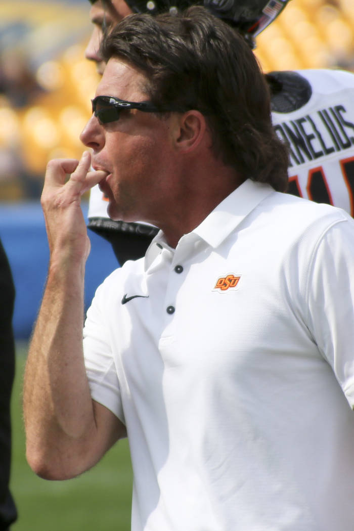 Oklahoma State head coach Mike Gundy whistles to get the attention of the officials in the fourth quarter of an NCAA football game Pittsburgh, Saturday, Sept. 16, 2017, in Pittsburgh. Oklahoma Sta ...