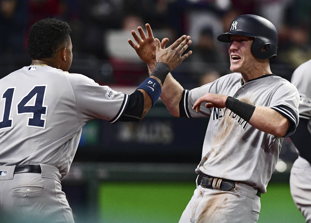 New York Yankees' Todd Frazier, right, celebrates with Starlin Castro after Frazier scored in the ninth inning of Game 5 of baseball's American League Division Series against the Cleveland Indians ...