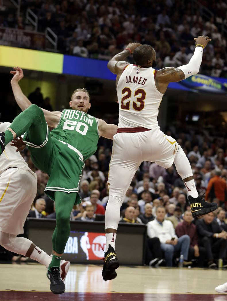 Boston Celtics' Gordon Hayward (20) falls as Cleveland Cavaliers' LeBron James (23) reaches for a loose ball in the first half of an NBA basketball game, Tuesday, Oct. 17, 2017, in Cleveland. Hayw ...
