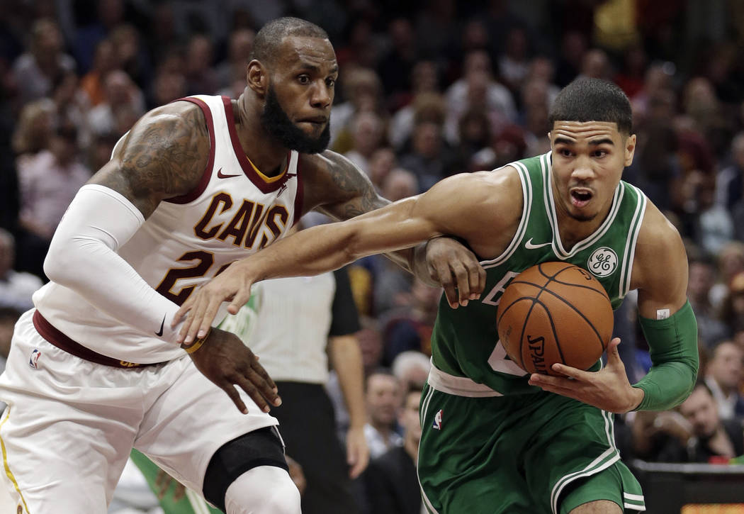 Boston Celtics' Jayson Tatum, right, drives past Cleveland Cavaliers' LeBron James in the first half of an NBA basketball game, Tuesday, Oct. 17, 2017, in Cleveland. (AP Photo/Tony Dejak)