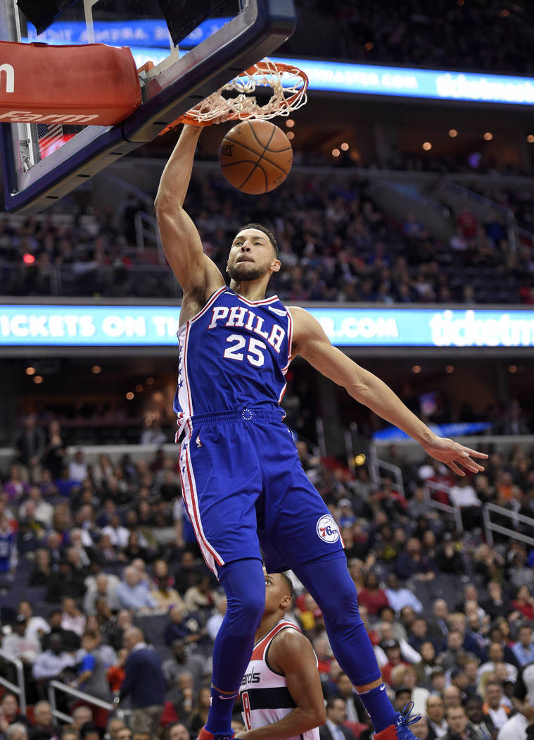 Philadelphia 76ers guard Ben Simmons dunks over Washington Wizards guard Tim Frazier, rear, during the first half of an NBA basketball game, Wednesday, Oct. 18, 2017, in Washington. (AP Photo/Nick ...
