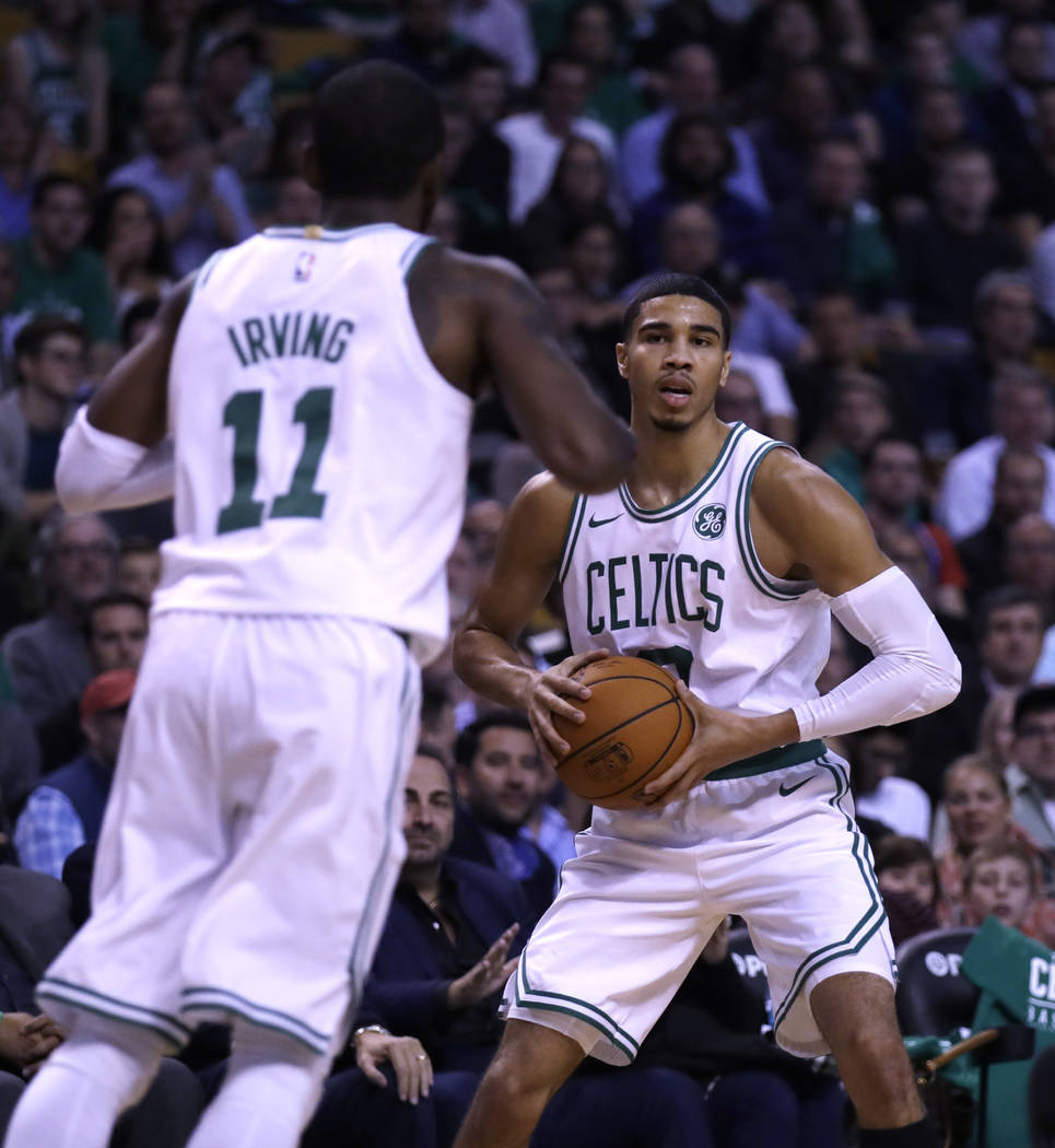 Boston Celtics forward Jayson Tatum, right, sets to pass to Kyrie Irving (11) during the first quarter of an NBA basketball game, Wednesday, Oct. 18, 2017, in Boston. (AP Photo/Charles Krupa)