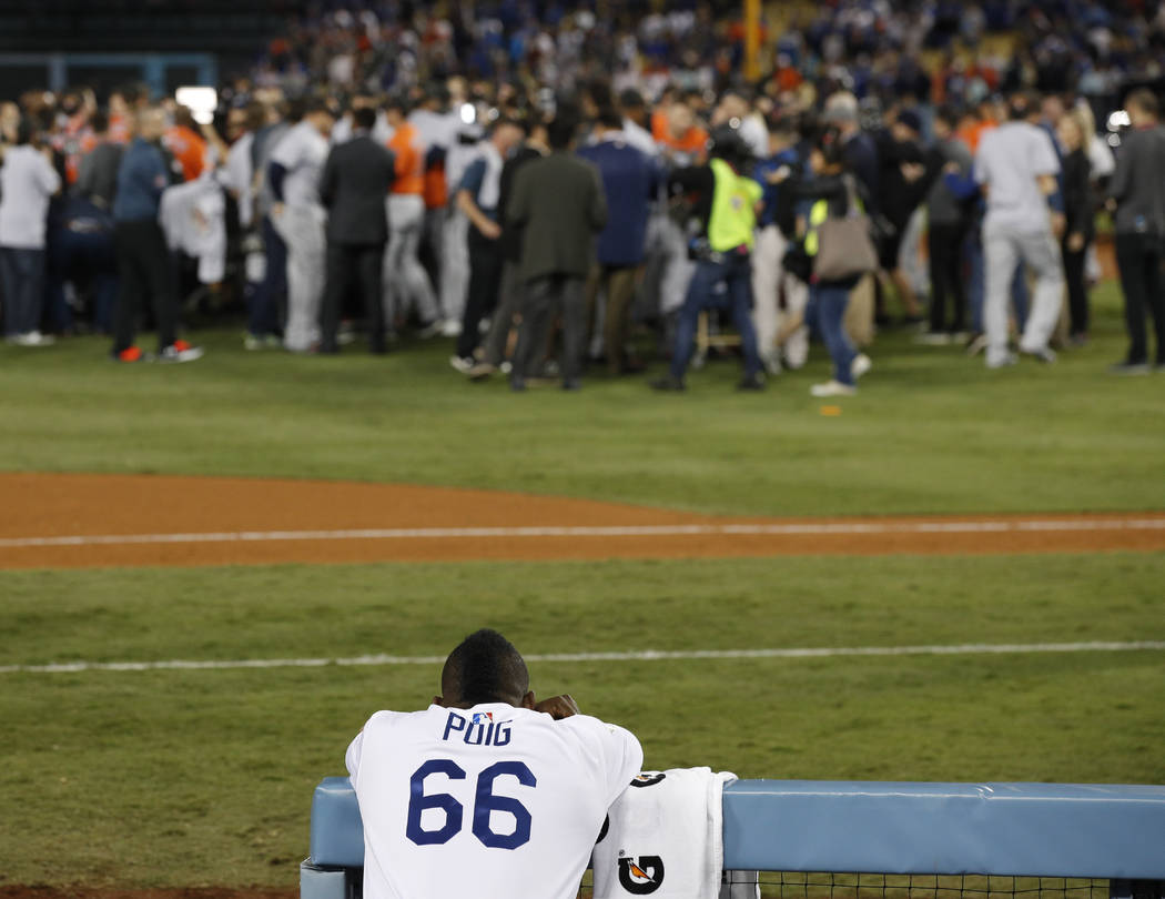 Los Angeles Dodgers right fielder Yasiel Puig watches as the Houston Astros celebrate their win in Game 7 of baseball's World Series Wednesday, Nov. 1, 2017, in Los Angeles. The Astros won 5-1 to  ...