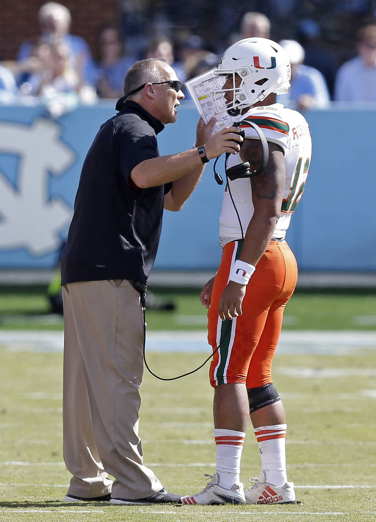Miami head coach Mark Richt speaks with quarterback Malik Rosier (12) during the first half of an NCAA college football game against North Carolina in Chapel Hill, N.C., Saturday, Oct. 28, 2017. ( ...