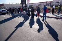 A line homeless people wait for food handouts on Foremaster Lane between Las Vegas Blvd. and Ma ...