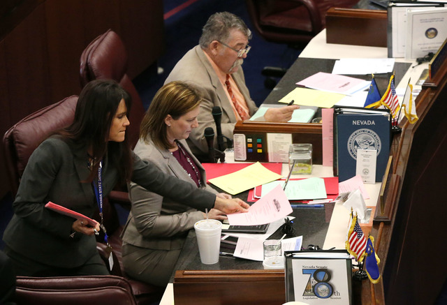 Nevada Senate Assistant Sgt.-at-Arms Teri Peterson hands out paperwork to Senate Republicans Becky Harris and Pete Goicoechea during the final hours of the session at the Legislative Building in C ...