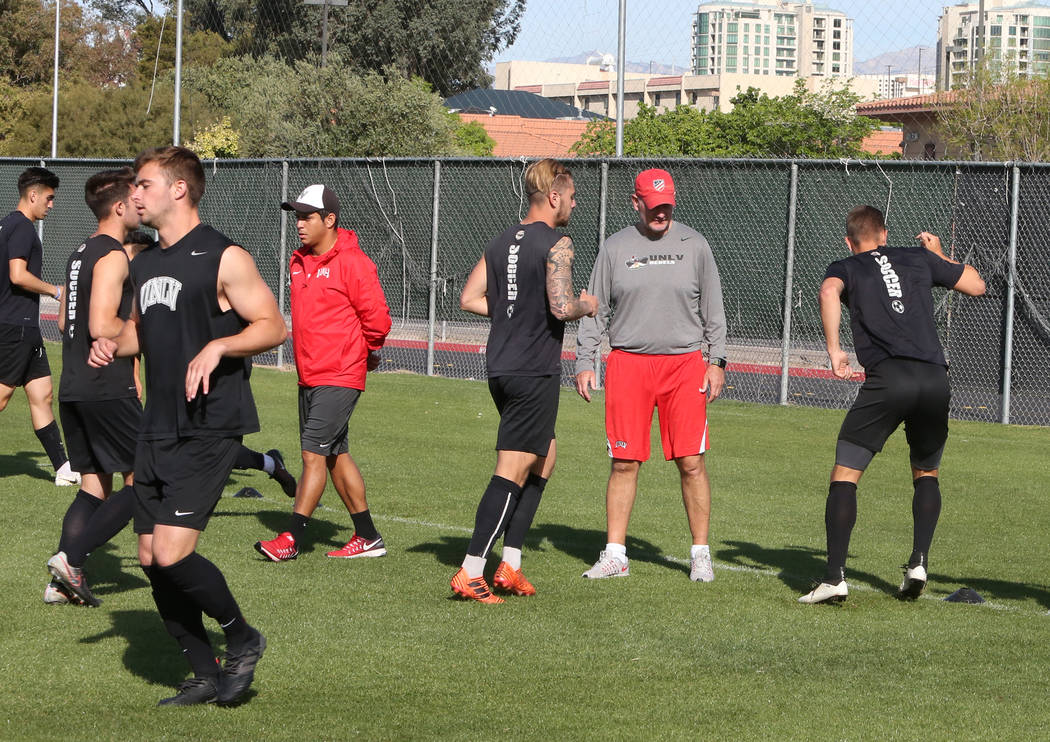 Rich Ryerson, UNLV soccer head coach, second right, and assistant coach Camilio Valencia, left, watch as their players warm up during team practice on Wednesday, April 18, 2018, in Las Vegas. Bizu ...