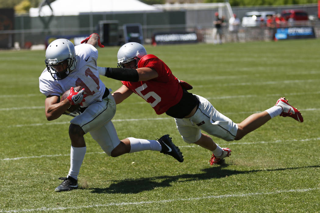 UNLV'S wide receiver Drew Tejchman (11) is tackled by defensive back Soli Afalava (15) during UNLV's spring football game at the Peter Johann Memorial Field in Las Vegas on Saturday, April 14, 201 ...