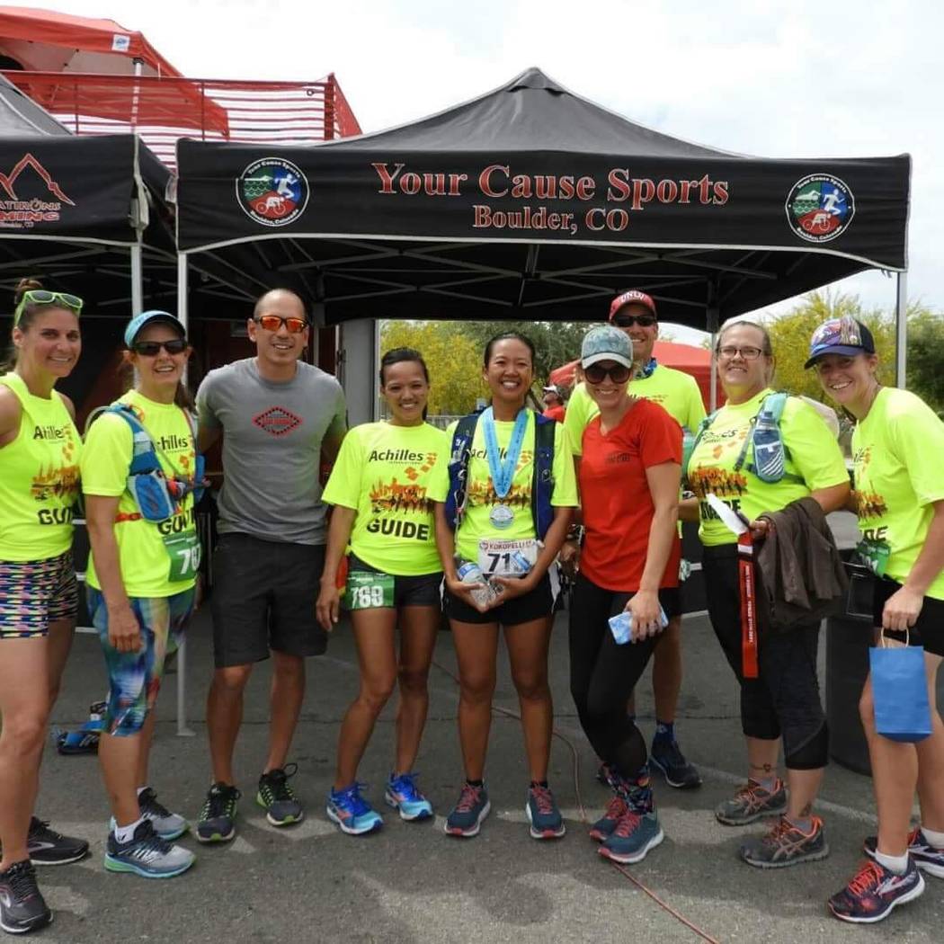 Terri Rupp, center, president of the National Federation of the Blind of Nevada, wears a medal after competing in a recent race. Achilles International assists visually impaired runners in their e ...