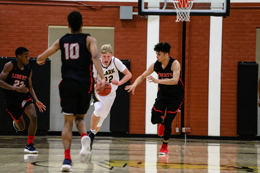 Clark Chargers' Trey Woodbury (22) dribbles the ball past Liberty's players during the second quarter of a basketball game at Ed W. Clark High School in Las Vegas, Friday, Dec. 15, 2017. Clark Cha ...
