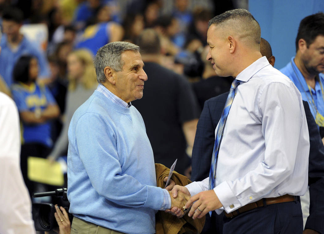 Jim Harrick, left, who coached UCLA's 1994-95 national championship team, greets UCLA assistant coach David Grace before the UCLA-Arizona State NCAA college basketball game in Los Angeles, Thursda ...