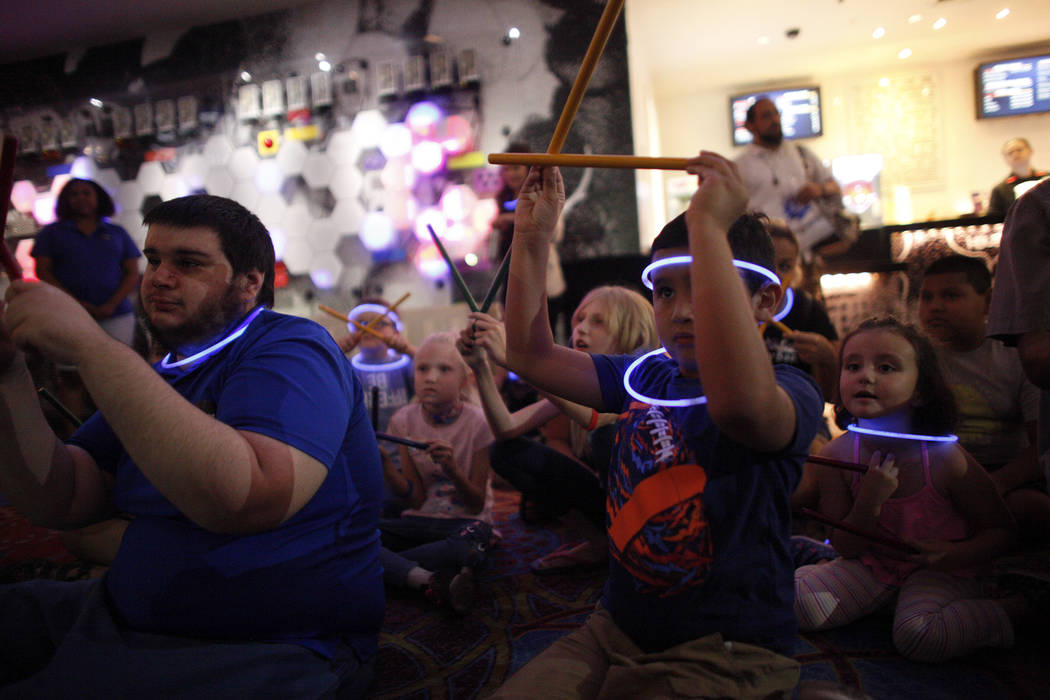 Joseph Giannotta, 19, left, plays along in a drum circle with Leo Murphy, 11, at the Luxor hotel-casino in Las Vegas, Sunday, June 10, 2018. The event took place before the Blue Man Groups' Grant ...