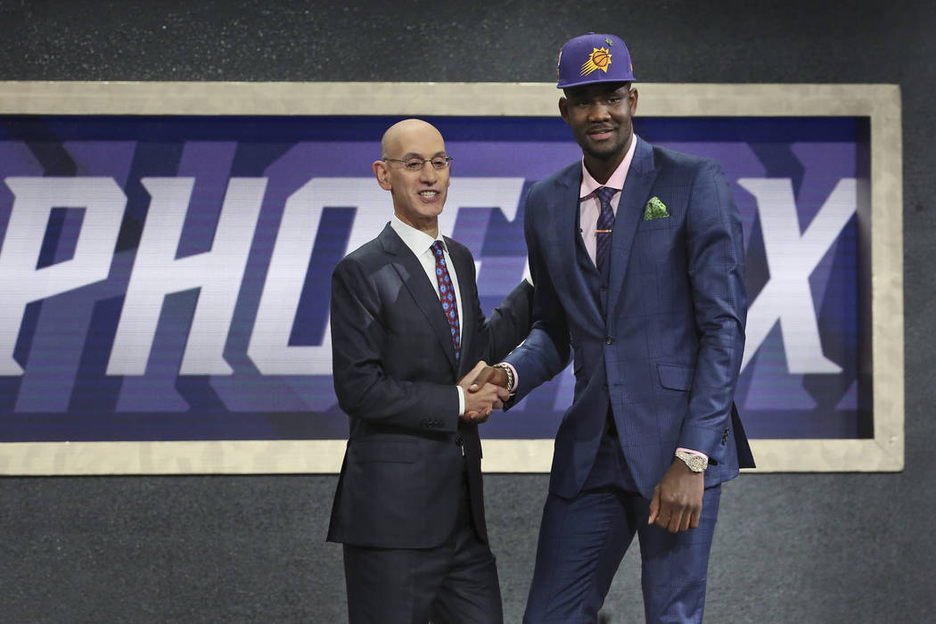 Arizona's Deandre Ayton, right, poses with NBA Commissioner Adam Silver after he was picked first overall by the Phoenix Suns during the NBA basketball draft in New York, Thursday, June 21, 2018. ...